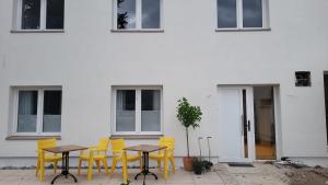 a group of yellow tables and chairs in front of a building at B&B Ut Zuuje in Valkenburg