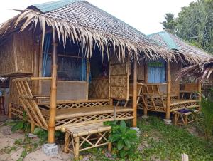 una casa con un banco y un techo de paja en Blue Moon Bungalow, en Ko Bu Bu