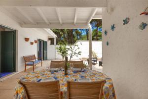 una mesa con sillas y un mantel en el patio en Villetta Specchiulla by BarbarHouse, en Conca Specchiulla