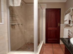 a shower with a glass door in a bathroom at Aviemore Lodge in Dullstroom +15 photos