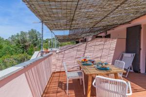 a wooden table and chairs on the balcony of a house at Villa del sole 4 in Capoliveri