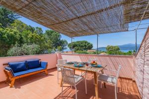 a table and chairs on a patio with a view of the ocean at Villa del sole 4 in Capoliveri