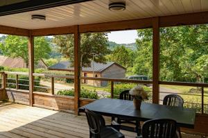 a screened in porch with a table and chairs at Grand chalet familial in Figeac