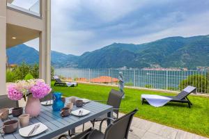 a table with a vase of flowers on a patio at Spa Stella Lario in Lezzeno