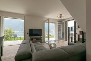 a living room with a couch and a television at Spa Stella Lario in Lezzeno
