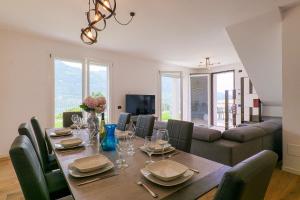 a dining room with a table and a couch at Spa Stella Lario in Lezzeno
