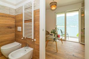 a bathroom with a toilet and a sink and a table at Spa Stella Lario in Lezzeno +33 photos