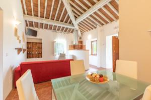 sala de estar con mesa de cristal y sofá rojo en Masseria del bosco Palazzone, en Chianciano Terme
