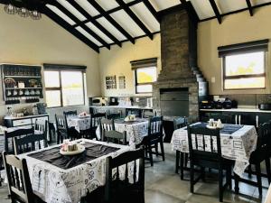 a dining room with tables and chairs and a fireplace at Calabash Executive Stay in Benoni