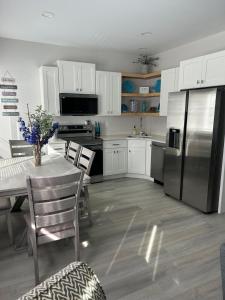 Una cocina con una mesa y un refrigerador de acero inoxidable. en The Hygge House, en Spirit Lake