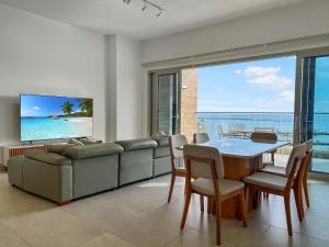 a living room with a couch and a table and chairs at Apartamento Playa Escondida Marina & Resort in María Chiquita