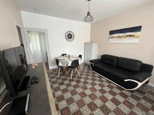 a living room with a black couch and a table at Le Devallon in Saint-Jean-de-Monts
