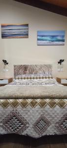 a bedroom with a bed with two pictures on the wall at Casa da Braña in Teo +25 photos