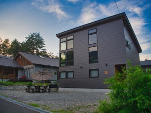 a building with a bench in front of it at Cosmique Chalet Hakuba in Hakuba