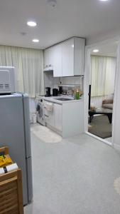 una cocina con estufa y refrigerador en Alley House 앨리하우스, en Seúl