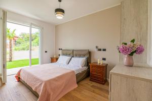 a bedroom with a bed and a vase of flowers at Spa Stella Lario in Lezzeno