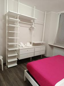 una camera da letto con un letto e una scaffalatura bianca di Central beautiful flat a pochi passi dal lago a Como