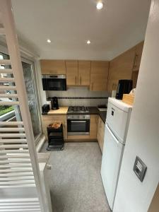 a kitchen with wooden cabinets and a white refrigerator at Comfortable Apartment in Brussels, 35 m², 3 Persons in Brussels