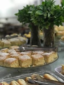 a bunch of pastries on a table with a vase at Hotel El Shaday in Nazário