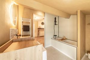 a bathroom with a tub and a sink in a room at Le Havre de Pierres, Puy du Foù in Mauléon +60 photos