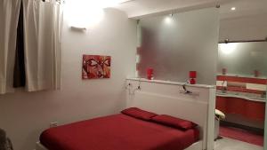 a bedroom with a red bed and a mirror at Villa Maddalena Bordighera in Bordighera