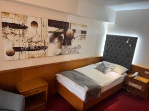 a bedroom with a bed and a painting on the wall at Hôtel des Trois Rois in Le Locle