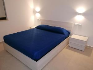 a bedroom with a blue bed and two night stands at A due passi dal mare Apartment in Capo dʼOrlando