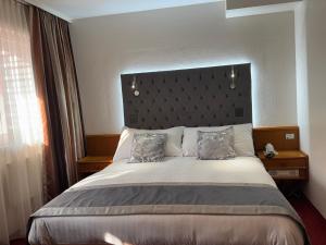 a bedroom with a large bed with a large headboard at Hôtel des Trois Rois in Le Locle +32 photos