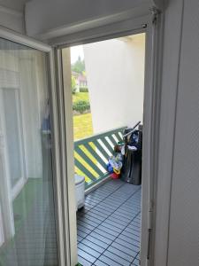 エヴィアン・レ・バンにあるAppartement Au bord du Lac de Genèveのポーチ付きのバルコニーへの開いたドア