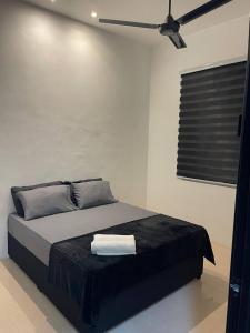 Gua SaiにあるRaroNa Homestay Kuantanのベッドルーム1室(ベッド1台、黒毛布付)