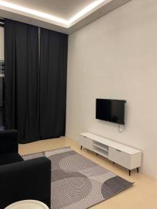 Gua SaiにあるRaroNa Homestay Kuantanの壁に薄型テレビが取り付けられたリビングルーム