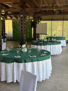 a row of tables with green and white table settings at Hotel Ciric in Iaşi +64 photos