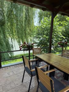 a wooden table and chairs on a deck with a view of a river at Hotel Ciric in Iaşi