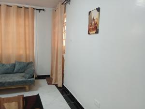 a living room with a couch and a clock on the wall at Leilani Homes in Kajiado
