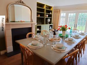 a dining room table with chairs and a large mirror at Charming Surrey Cottage perfect for Autumn or Winter gatherings in Great Bookham +25 photos