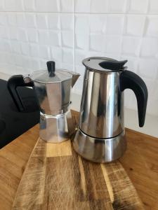 a coffee pot and kettle on a wooden table at Vilamar - Ribamar in Ribamar