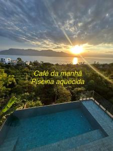 een uitzicht op een zwembad voor een zonsondergang bij Maluhia Ilhabela 1 in Ilhabela