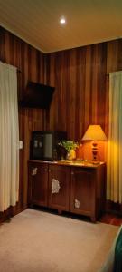 a room with a table with a lamp and a television at Morada das Mandalas in Pomerode +27 photos