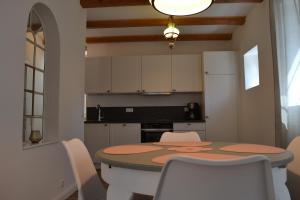a kitchen with a table and white chairs and a kitchen with a table at Ferienhaus Heidefee in Wietzendorf