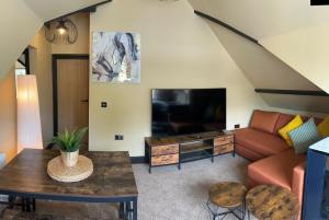 a living room with a couch and a tv at The Goodrington Sands- Apart Hotel in Paignton