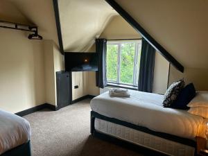 a room with two beds and a tv and a window at The Goodrington Sands- Apart Hotel in Paignton