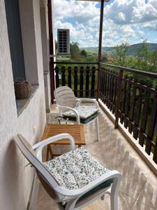 two chairs and a table on a balcony with a view at Узунови Апартамент Трявна леик in Tryavna