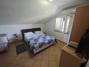 a bedroom with a bed and a tv in it at Apartments Stana in Sukošan