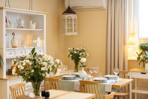 a dining room with a table with flowers on it at Hotel Boss in Łódź