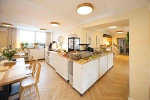 a kitchen with white cabinets and a table and a dining room at Hotel Boss in Łódź