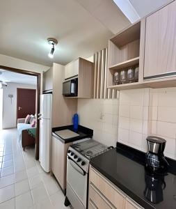 a small kitchen with a stove and a refrigerator at AP em Baln. Caiobá a 2 quadras do mar. in Matinhos +16 photos