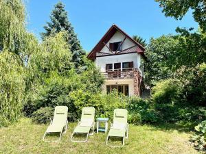 een groep ligstoelen en een huis bij Vadrózsa apartman in Badacsonytomaj