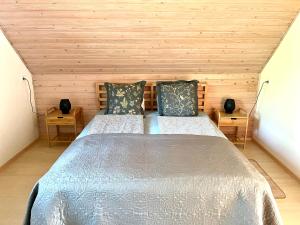een groot bed in een kamer met houten wanden bij Vadrózsa apartman in Badacsonytomaj