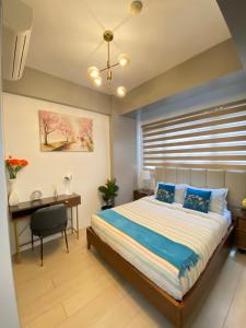a bedroom with a bed and a desk and a window at One Manchester Place Mactan Newtown in Lapu Lapu City +70 photos