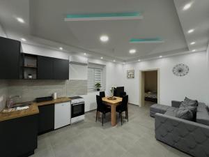a kitchen and living room with a table and a couch at Apartman Mila in Bogojevo